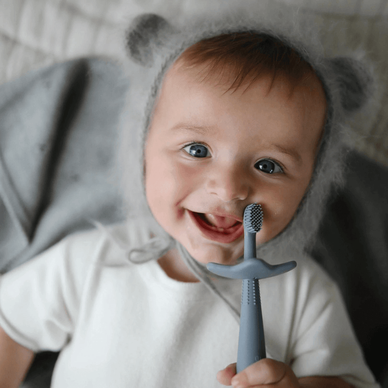 Baby enjoying his playfully designed toothbrush